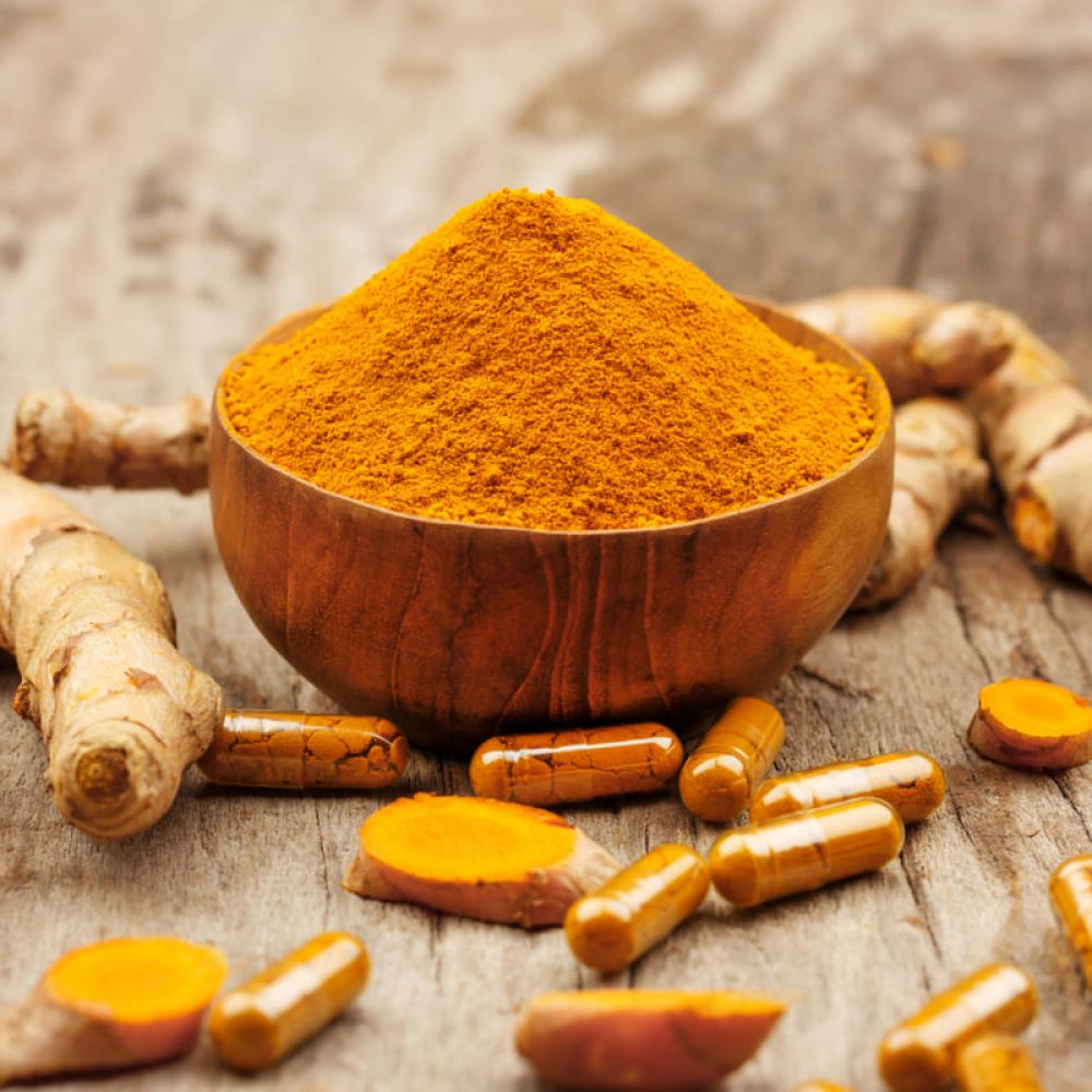 turmeric-powder-wooden-bowls-turmeric-capsules-wooden-background